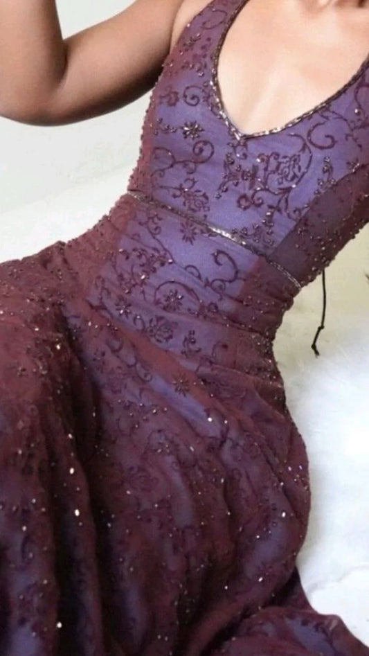 Back view of a purple mermaid gown showing an open halter back and a dramatic lace sweep train, perfect for red carpet events.