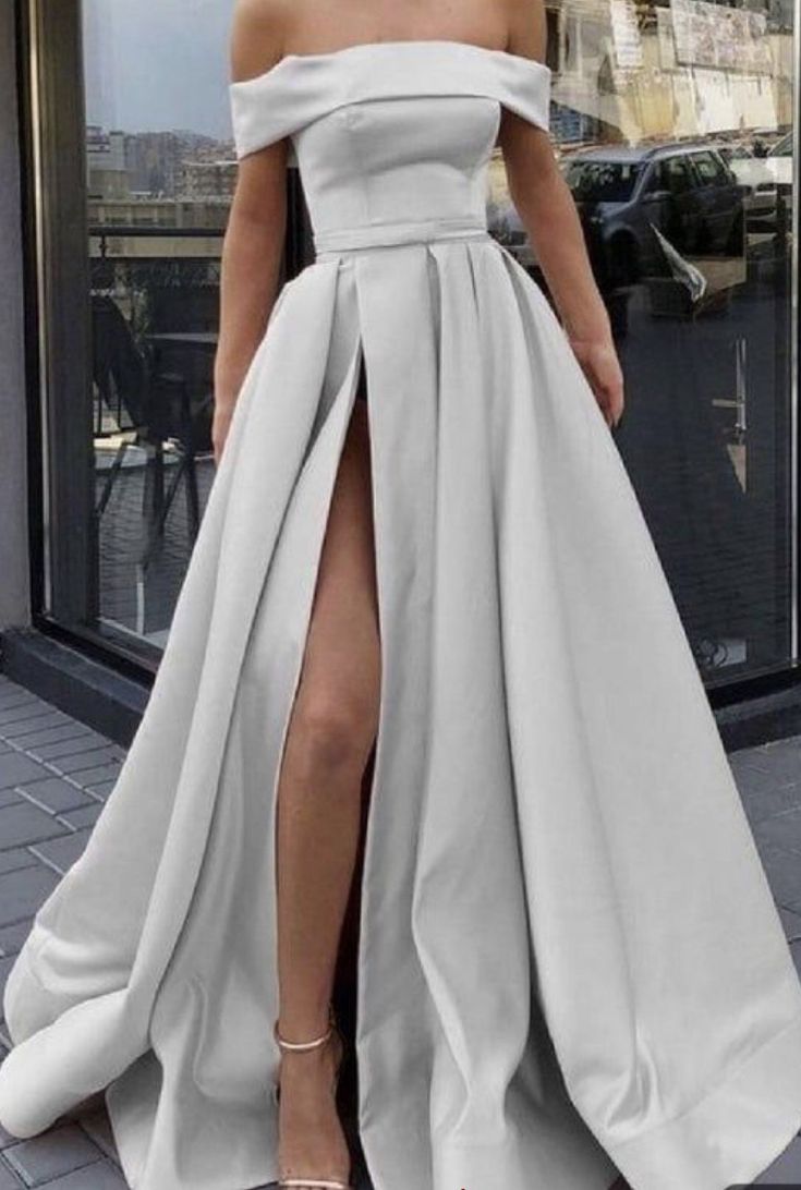 Woman wear a silver prom dress , she shows the beautiful dress